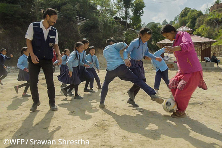 国連WFP日本人職員の金子彰さんが小学校の児童と一緒にサッカーに参加する様子の写真